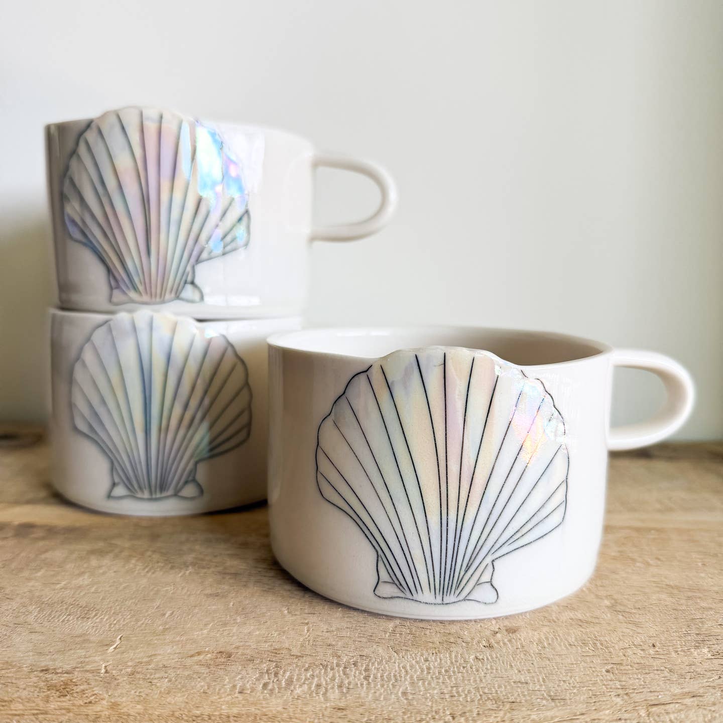 Seashell mugs are hand-thrown from fine porcelain, and feature hand drawn inlay and mother of pearl luster for a delicate and iridescent shine.