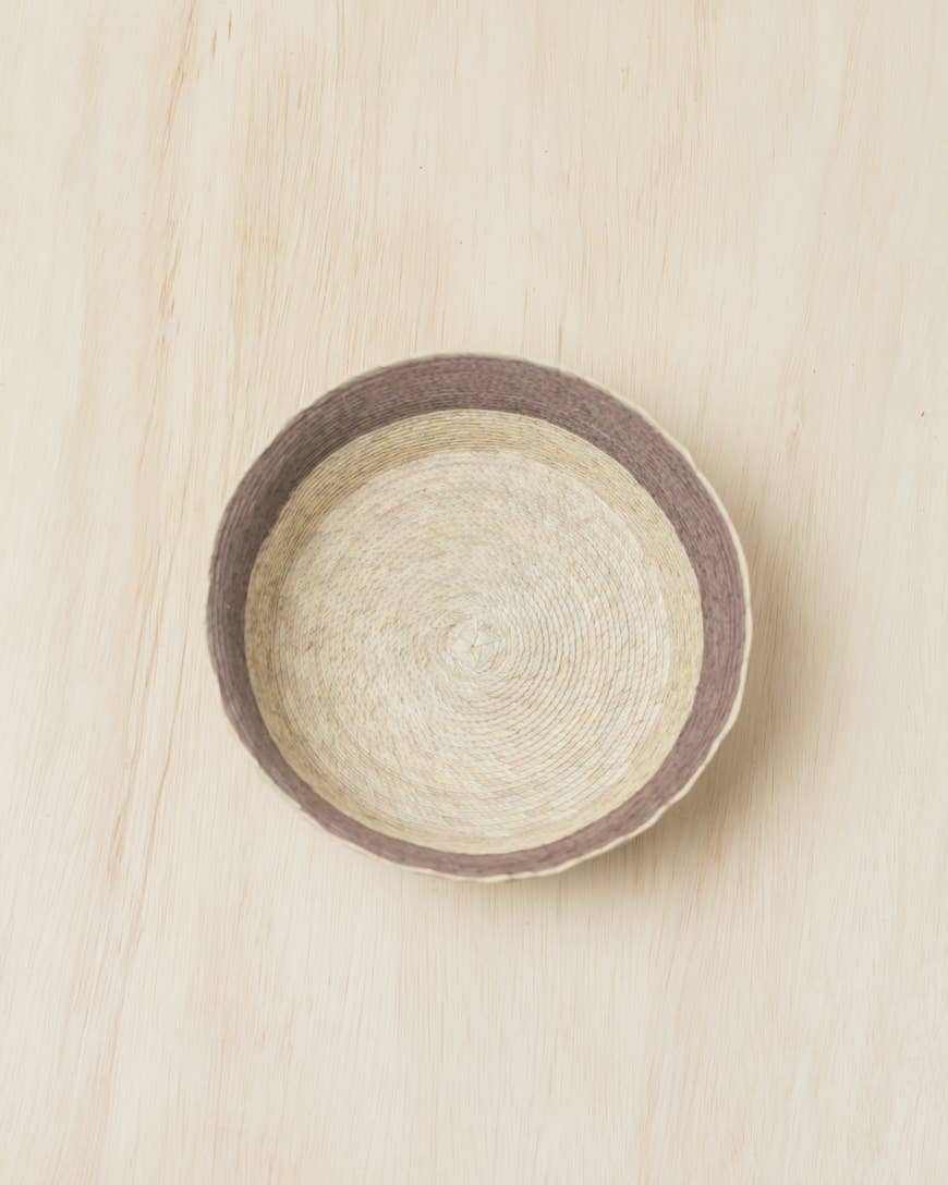 In the mountains of Southern Mexico, artisans weave these exquisite baskets from sun-dried palm leaves. Each takes days to complete using traditional skills passed down through generations. This versatile design pairs the beautiful hues of natural fiber with a block of subtle earthy color.