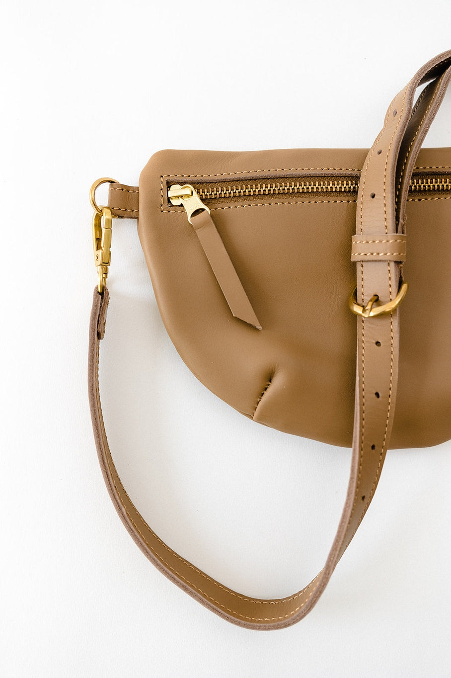 Fair trade and adjustable leather sling bag/fanny pack. Adjust the length to fit your needs. Handcrafted, vegetable tanned leather sling bag made in Kenya with locally and ethically-sourced materials. A portion of sales go to an organization in Tanzania empowering children living on the street.