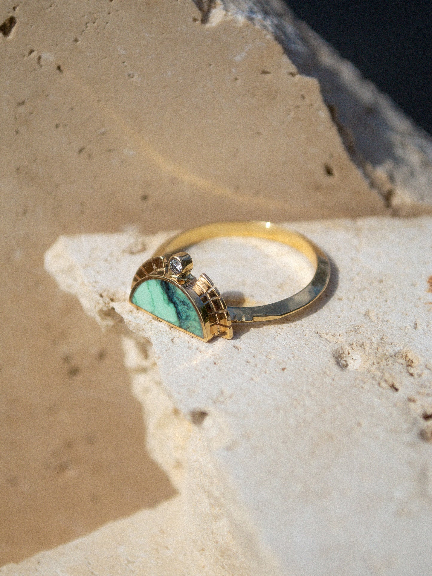 young in the mountains / A half circle of warm 14k yellow gold is wrapped around an inlaid Angel Wing Variscite stone while a serrated halo of light complete with a centered .03 white diamond radiates from this sun