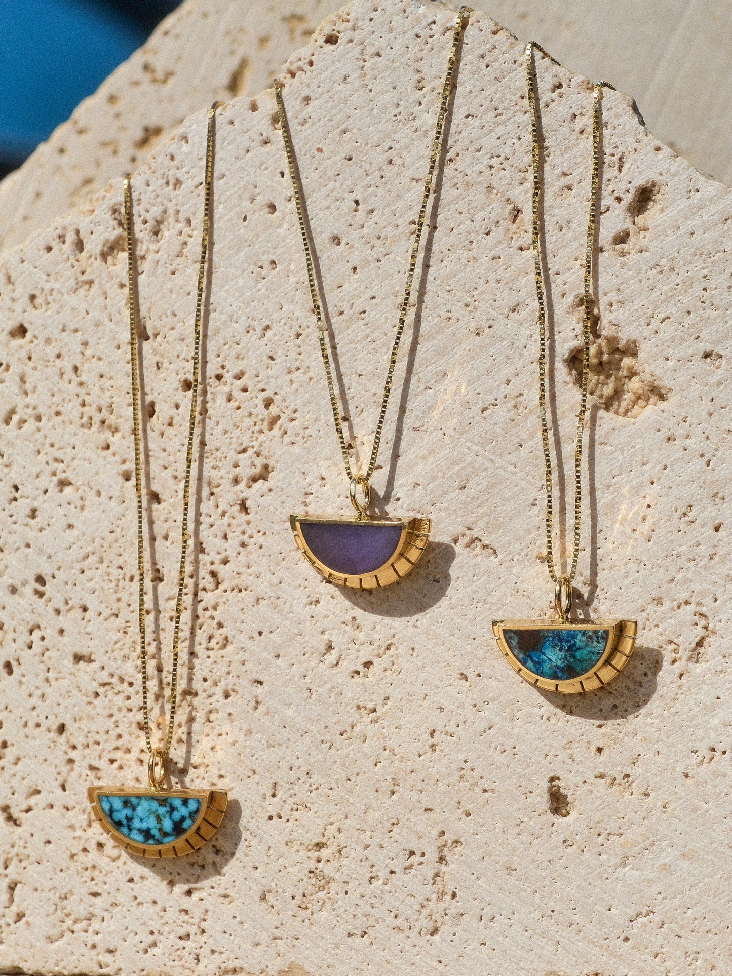 young in the mountains / A half circle of warm 14k yellow gold is wrapped around an inlaid Burro Creek Jasper stone while a serrated halo of light radiates from this sun. This pendant hangs freely on a 14k yellow gold box chain.