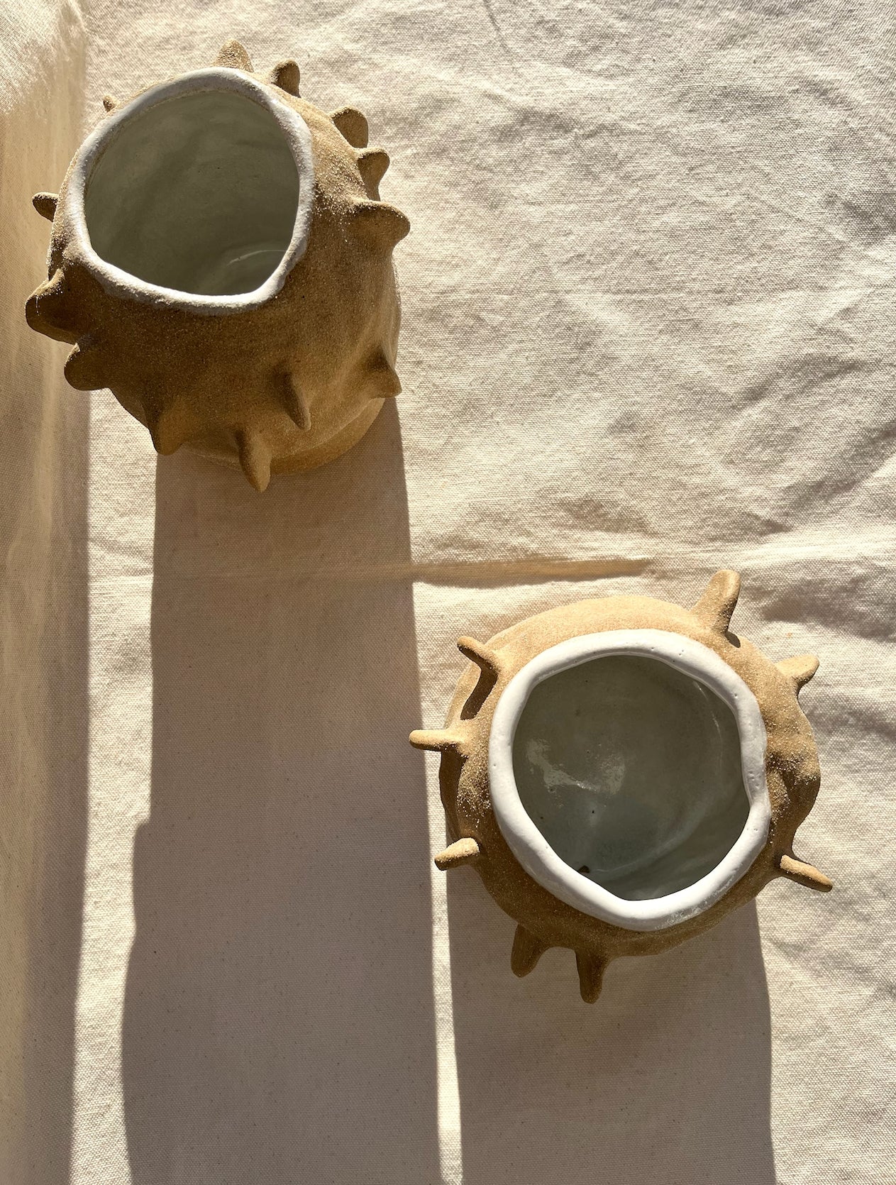 An organic vase with a speckled, textured clay body and white glaze on the inside. A vase for your fresh or dried flowers, yes… but also an alcove to place a teeny treasure to compliment them. Hand built, glazed and fired in Slo, Ca.