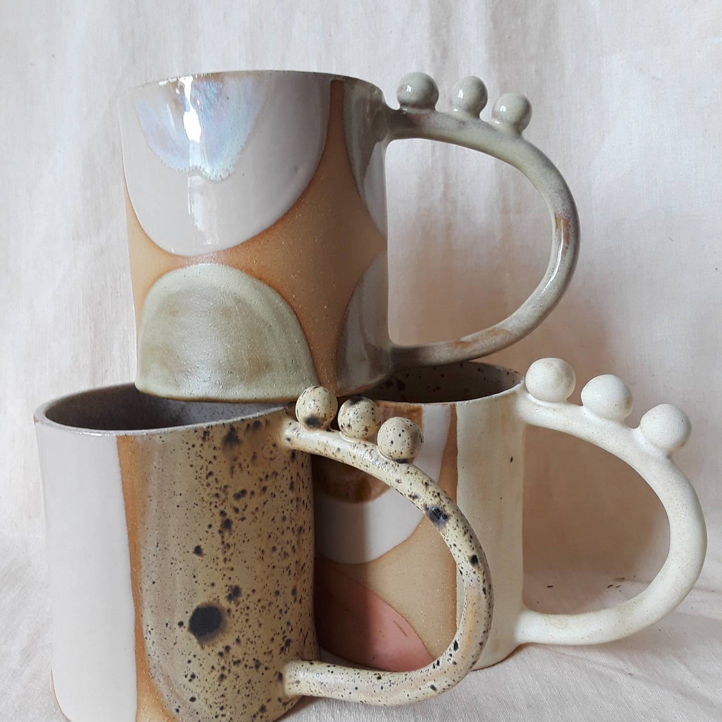 Handmade ceramic mug featuring unique glaze colors & ball accents atop a looped handle. Each is entirely one of a kind, all including gold luster to help you shine all day long. Handmade by Curious Clay in Virginia.