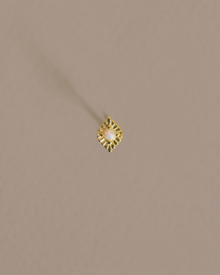 A lovely little handmade eye style stud that lays flat and boarders a vibrant prong set opal gem. Handmade in the Santa Cruz Mountains.