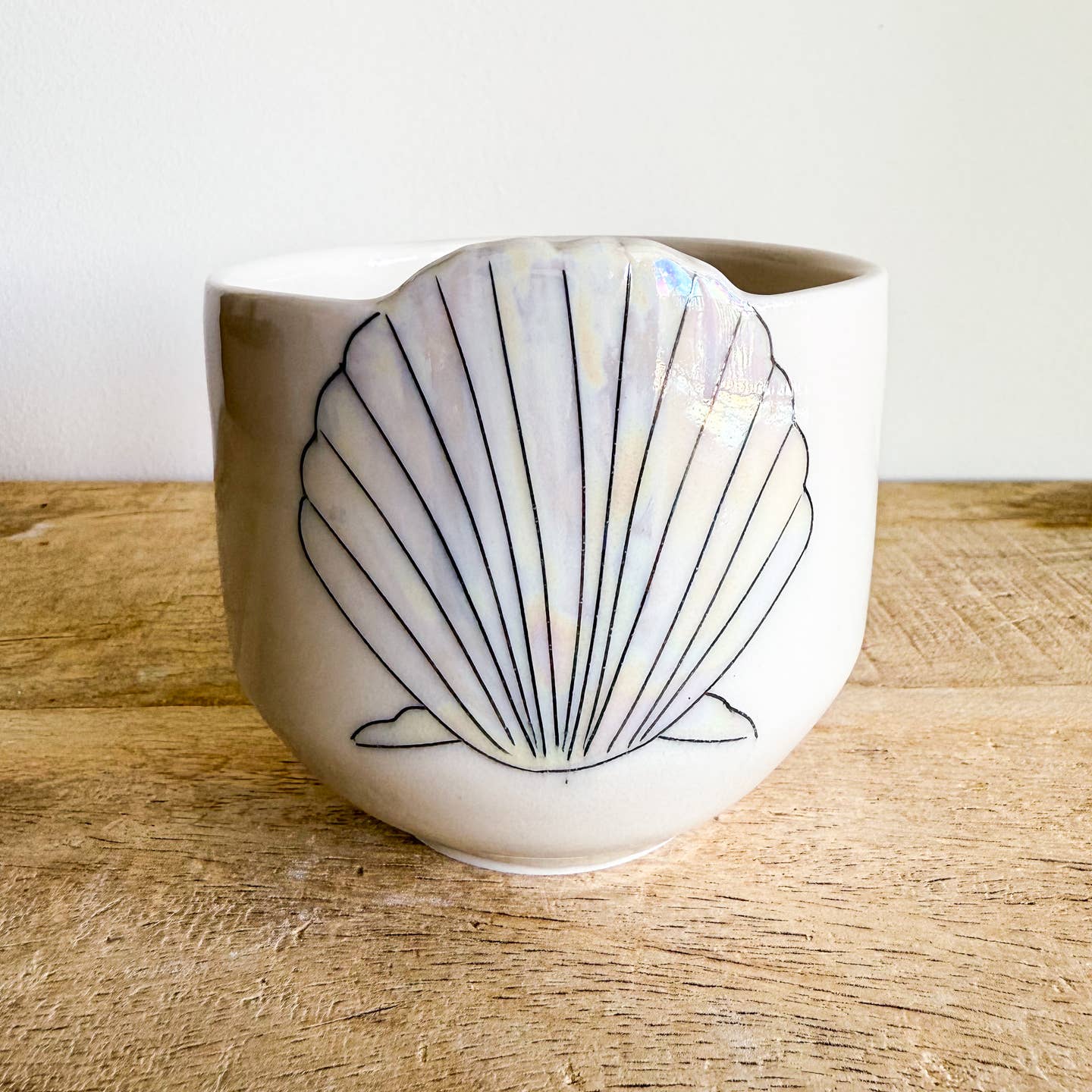 Seashell cups are hand-thrown from fine porcelain, and feature hand drawn inlay and mother of pearl luster for a delicate and iridescent shine.