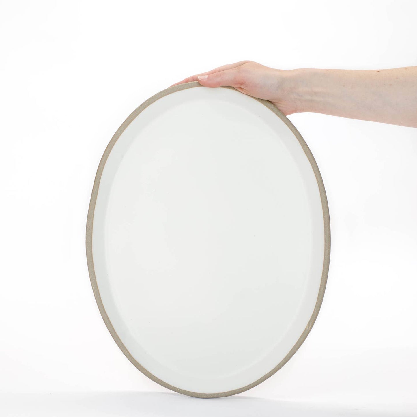 Hand-built with shallow walls, some organic quality around the rim, and a flat base, this ceramic platter is designed for serving. Use it as a charcuterie board, snack platter, coffee table tray, or your main course! Handmade in Virginia