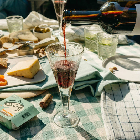 Unique blown glass champagne glass amongst a lively holiday backdrop