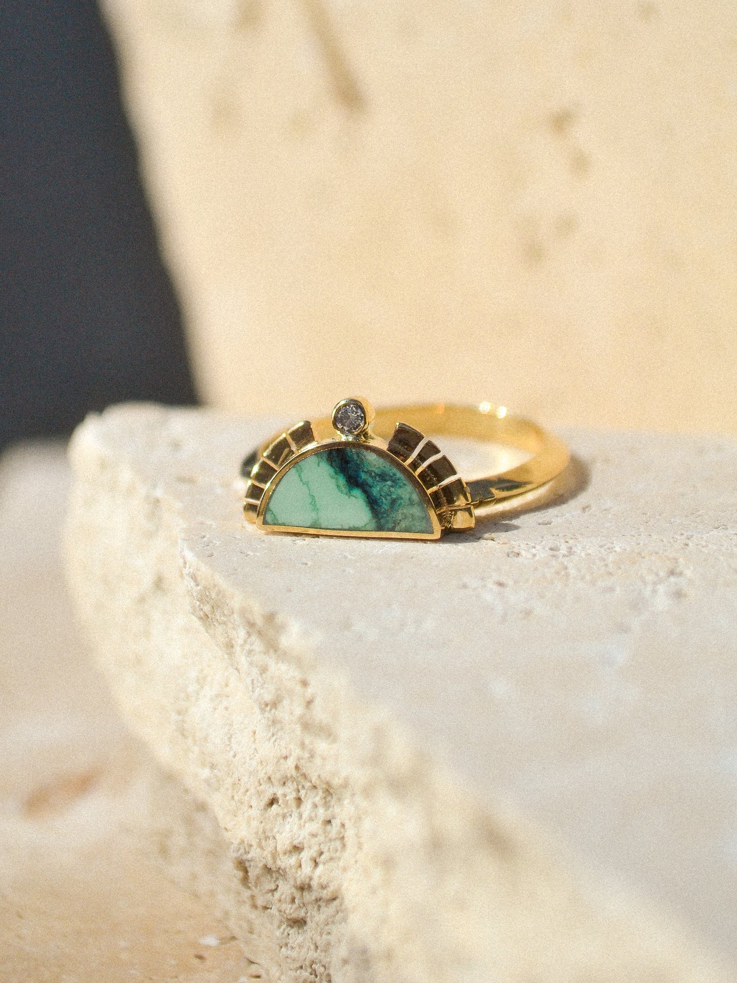 young in the mountains / A half circle of warm 14k yellow gold is wrapped around an inlaid Angel Wing Variscite stone while a serrated halo of light complete with a centered .03 white diamond radiates from this sun