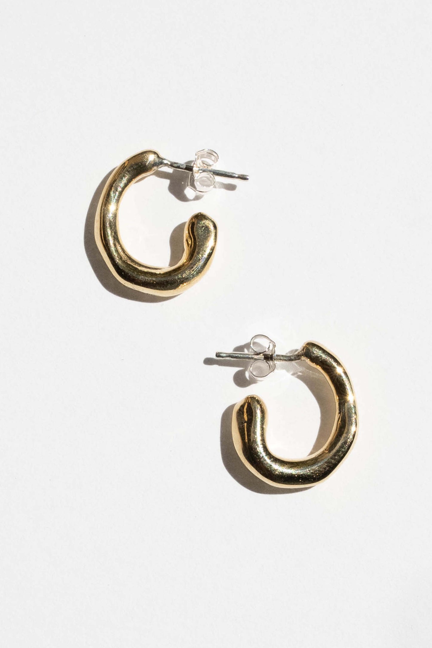 moneh brisel jewelry / The Fluid hoops embody the abstract and playful shape of water. The soft round edges and organic details serve as a reminder to flow with the day ahead of you. Perfect mini everyday hoops.