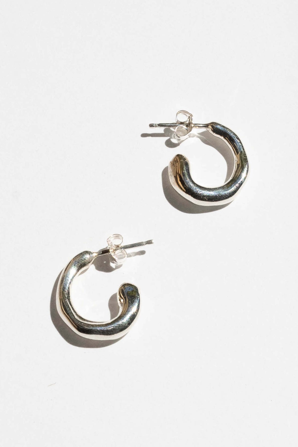 moneh brisel jewelry / The Fluid hoops embody the abstract and playful shape of water. The soft round edges and organic details serve as a reminder to flow with the day ahead of you. Perfect mini everyday hoops.\