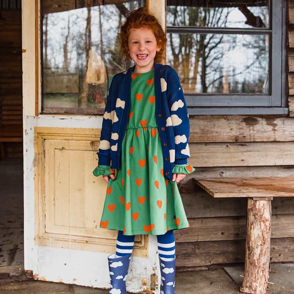 Green velvet long sleeved dress with a red heart print made with 95% organic cotton. Ethically produced, colorful and fun with an eye towards comfort, style and joy. Modern and sustainable kids clothing by CarlijnQ of the Netherlands.