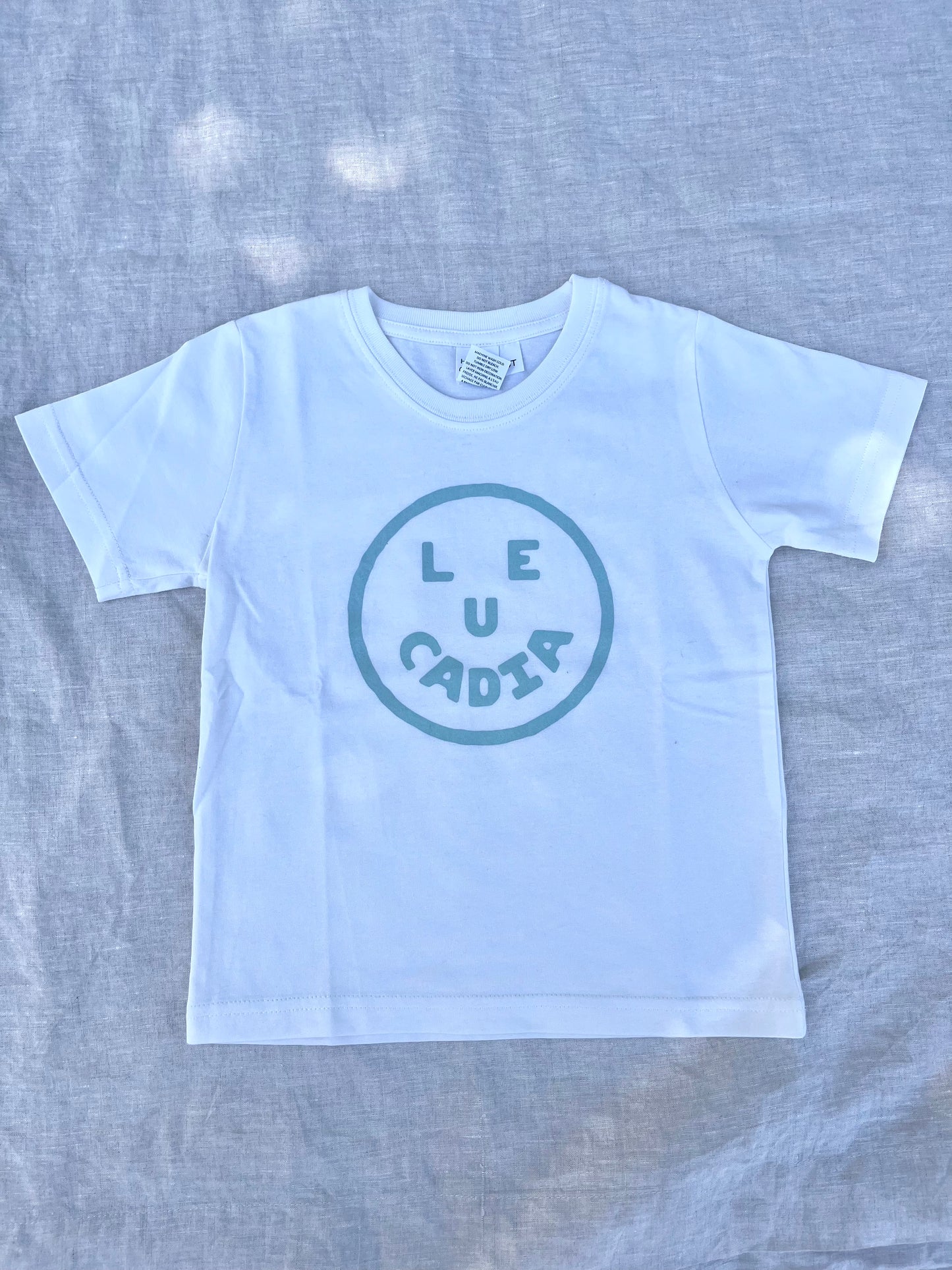 A fun little organic kids tee with a super cute little Leucadia smiley face by local artist Zach Smith. Printed on an organic cotton, fair trade tee with all proceeds to San Diego area families facing housing insecurity. Keep it funky, keep it kind, keep it local.