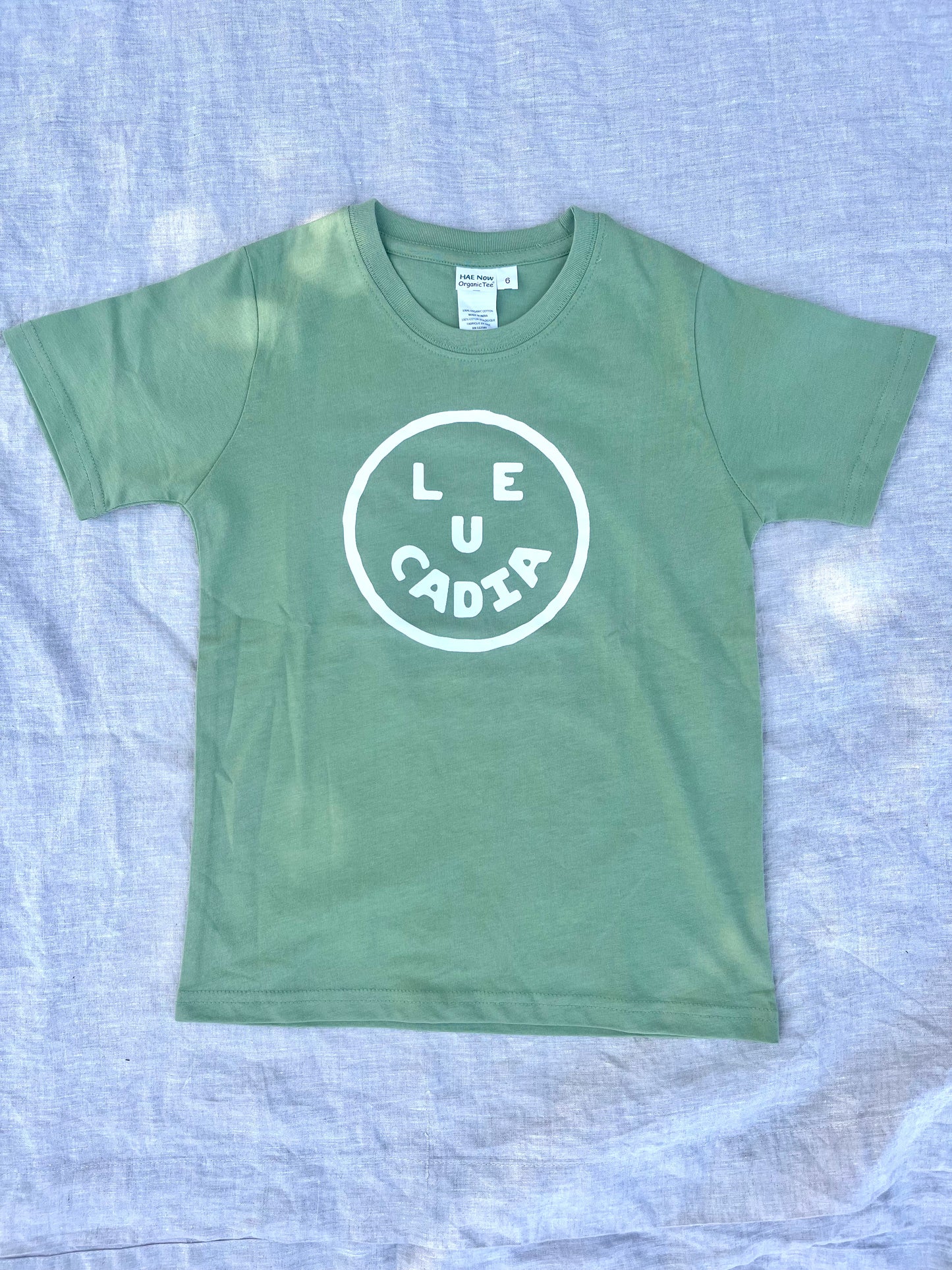 A fun little organic kids tee with a super cute little Leucadia smiley face by local artist Zach Smith. Printed on an organic cotton, fair trade tee with all proceeds to San Diego area families facing housing insecurity. Keep it funky, keep it kind, keep it local.