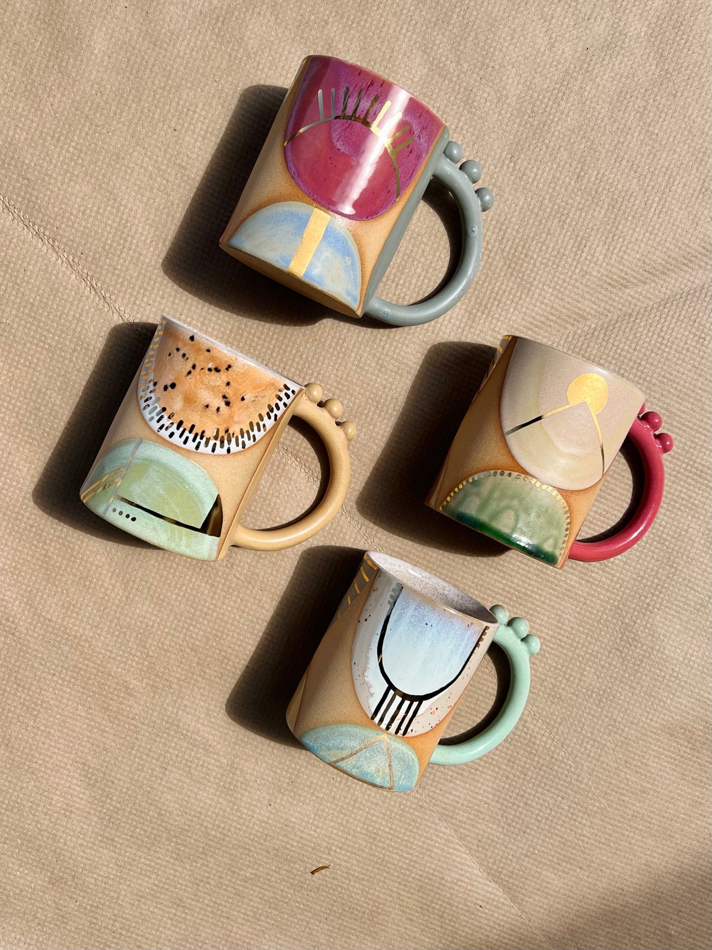 Handmade ceramic mug featuring unique glaze colors & ball accents atop a looped handle. Each is entirely one of a kind, all including gold luster to help you shine all day long. Handmade by Curious Clay in Virginia.