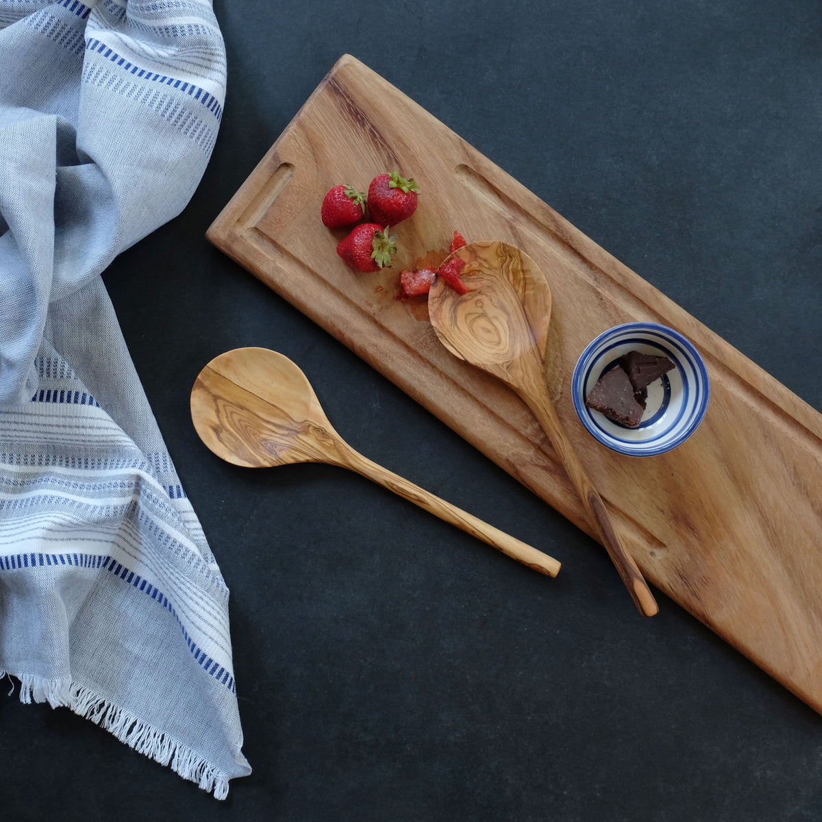 Handmade and ethically made olive wood serving spoon made in Tunisia. Each olive wood piece has a unique luster from the natural grain of the wood, easily maintained with food safe oil.