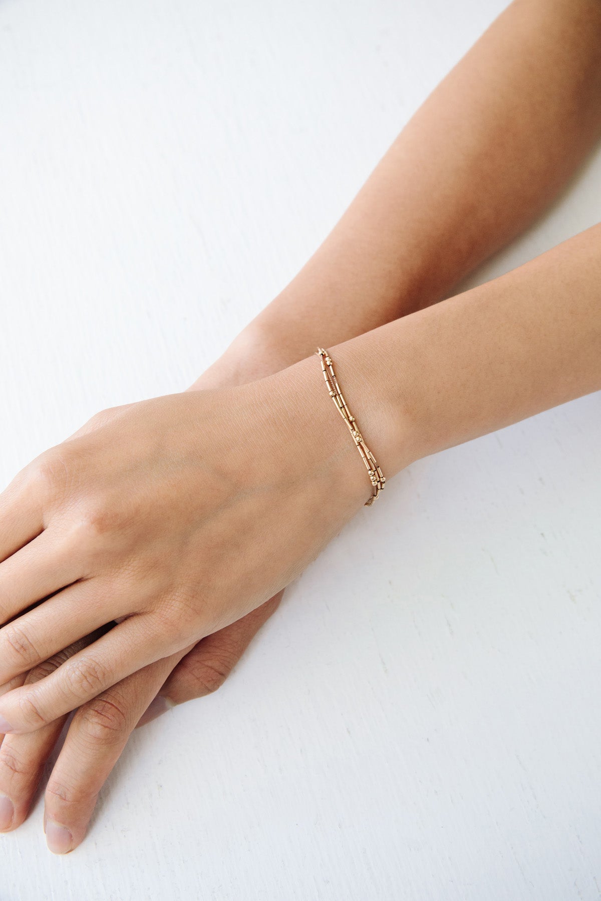 A refined and effortless bracelet designed to elevate your day-to-day. The Ara is a triple-stranded silk cord bracelet stacked with gold tubes and rounds that shift freely.
