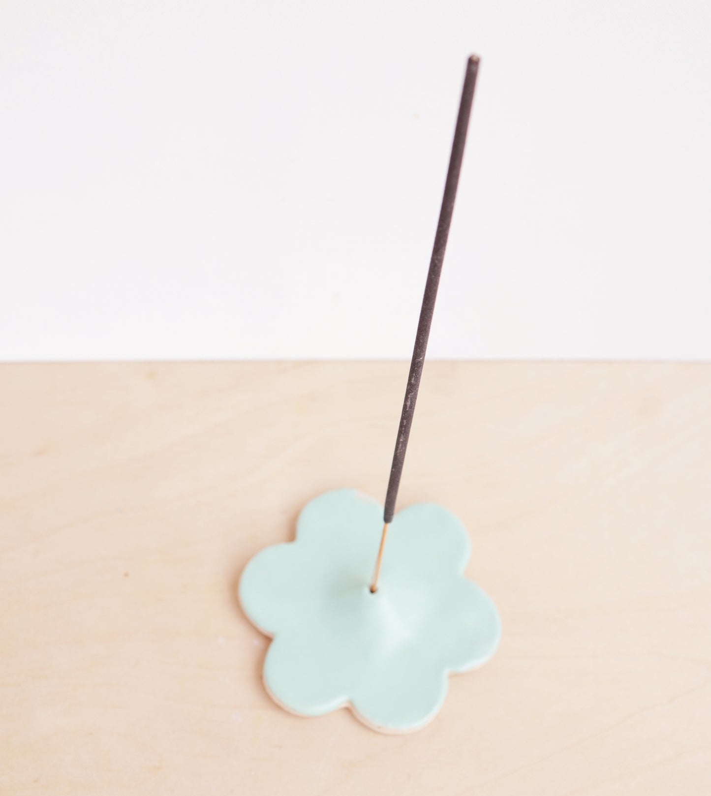 Modern, minimalist incense holder in a simple floral design. A bright satin glaze finishes the piece.
