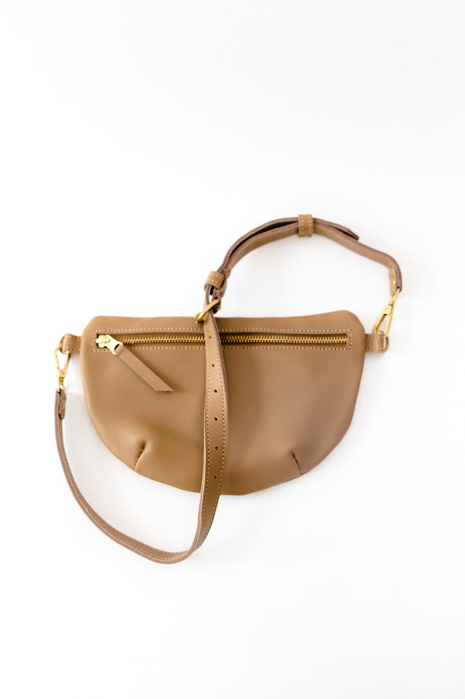 Fair trade and adjustable leather sling bag/fanny pack. Adjust the length to fit your needs. Handcrafted, vegetable tanned leather sling bag made in Kenya with locally and ethically-sourced materials. A portion of sales go to an organization in Tanzania empowering children living on the street.