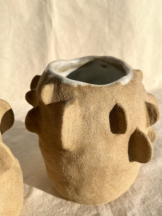 An organic vase with a speckled, textured clay body and white glaze on the inside. A vase for your fresh or dried flowers, yes… but also an alcove to place a teeny treasure to compliment them. Hand built, glazed and fired in Slo, Ca.