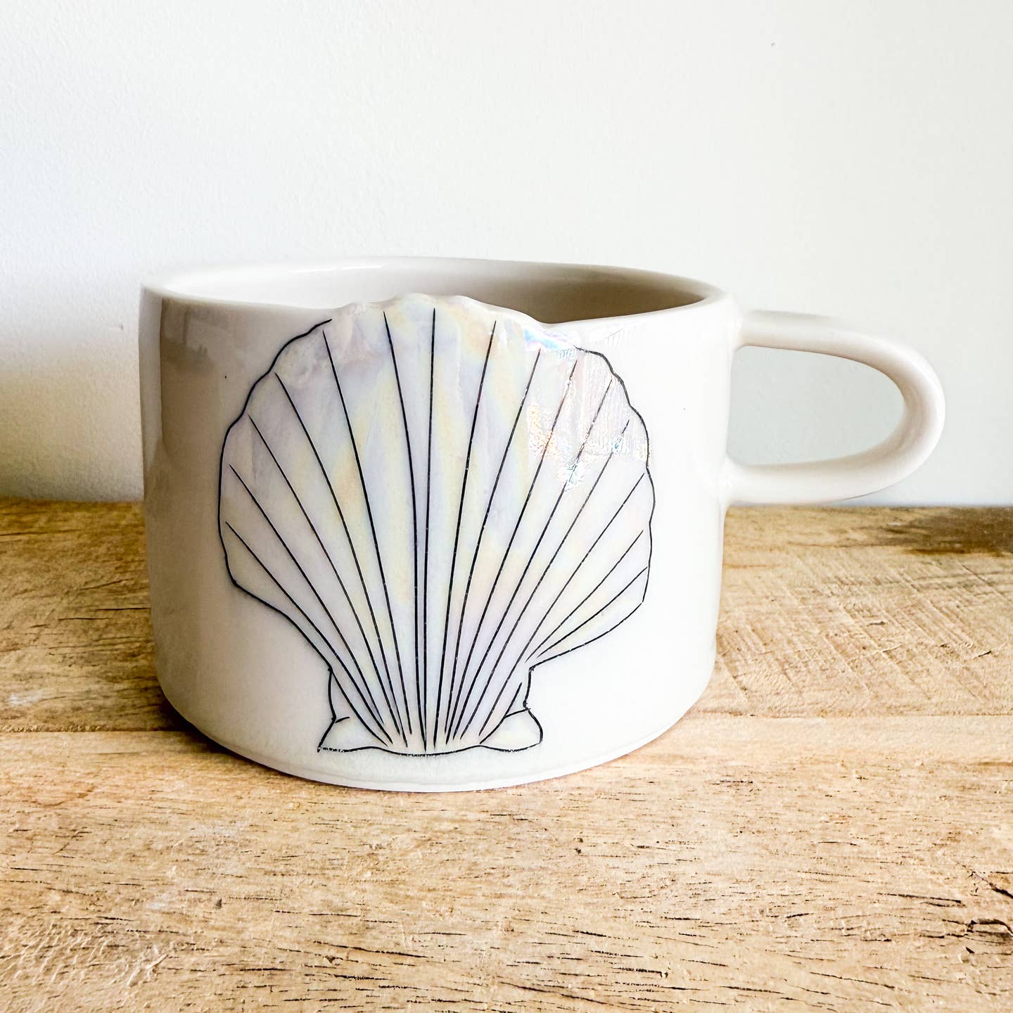 Seashell mugs are hand-thrown from fine porcelain, and feature hand drawn inlay and mother of pearl luster for a delicate and iridescent shine.