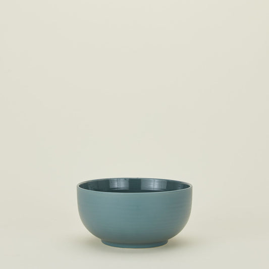 Blue ceramic bowl on a beige background - Hawkins New York Essential Serving Bowl
