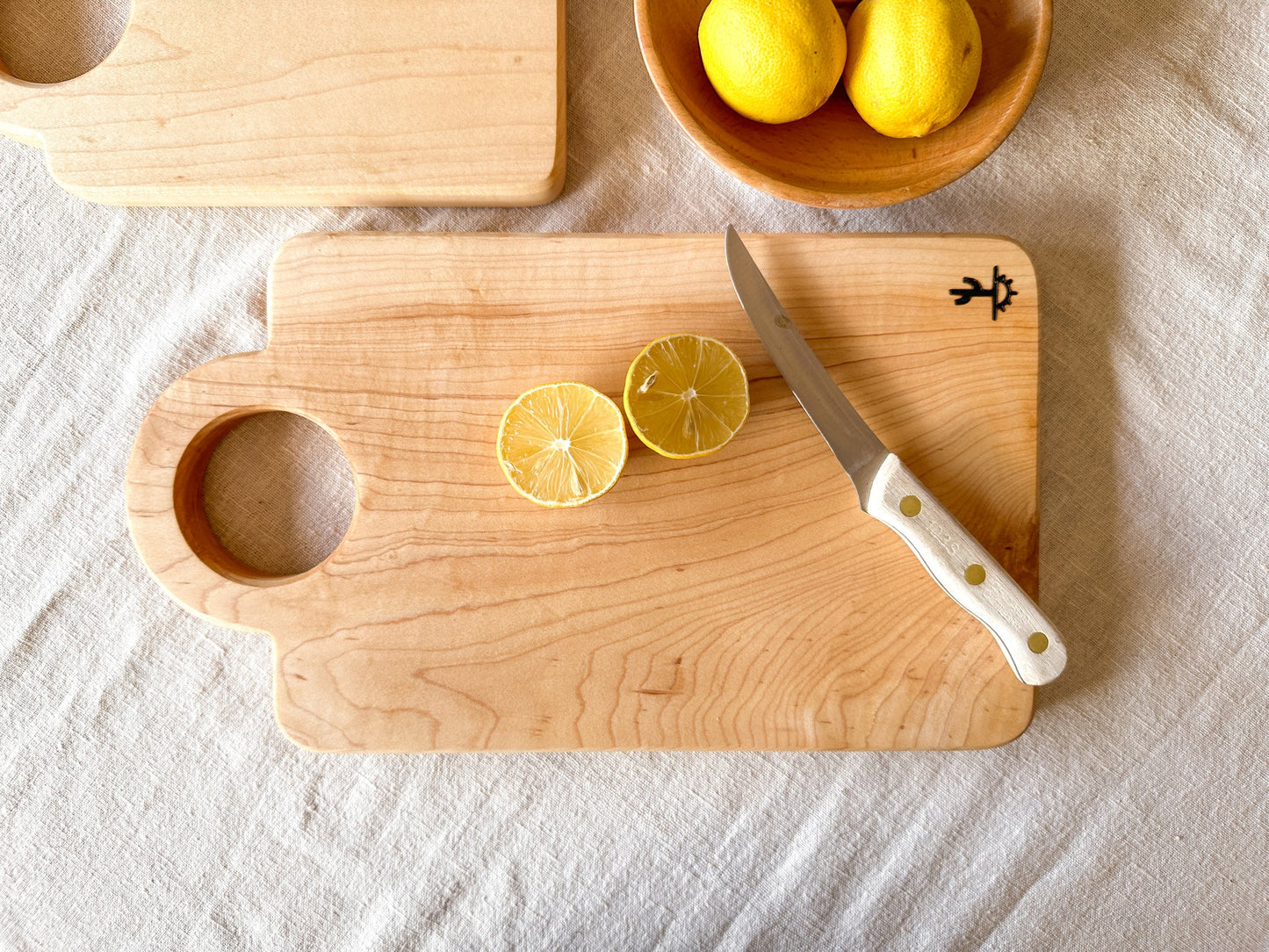 A modern design featuring a circular handle. These are made out of either hard maple that is know for its neutral grain and durable surface or dark walnut that is know for its moody grain with stripes of caramel. Great boards to grab for a quick chop or made as your designated home bar board for citrus.