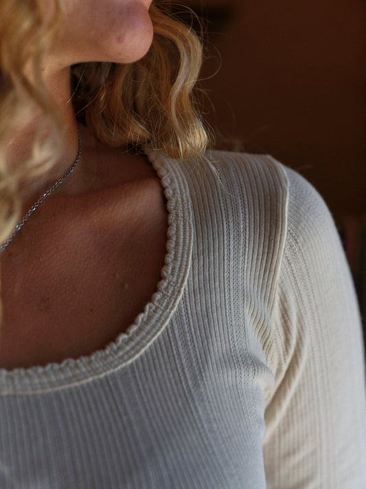 Close-up of a person wearing a light-colored top with a blurred background. Mollusk Surf Shop Pointelle Long Sleeve Tee
