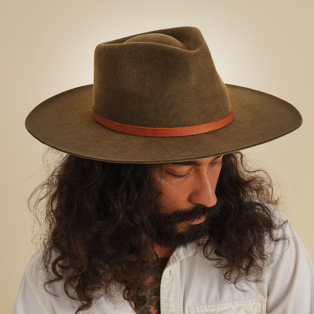 Minga's classic Rancher hat design, handmade from sheep's wool, is the perfect touch of sophistication. Wide-brimmed with a teardrop crown, and finished with a vegetable-tanned leather tie. Crafted with natural fibers makes for a versatile, all-season hat.