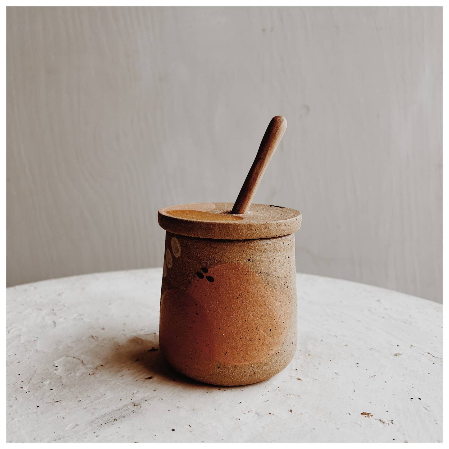 Painted dune honey pot with hand carved stick. Glazed interior with raw clay exterior. Painted accents in dusty pink, burnt orange and light blue with black specks. Each piece is crafted by the same set of hands, which belong to Andi at Good Hearted Woman. Based in Denver, CO.