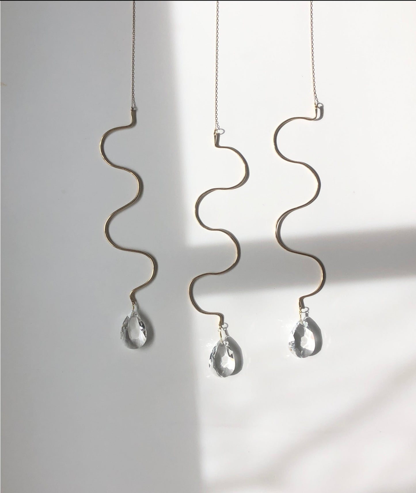 Artisan-crafted sun catcher made from hand forged/hammered brass wire and vintage faceted crystal. Ready to hang by your window where the light pours in and watch the rainbows dance around the room!