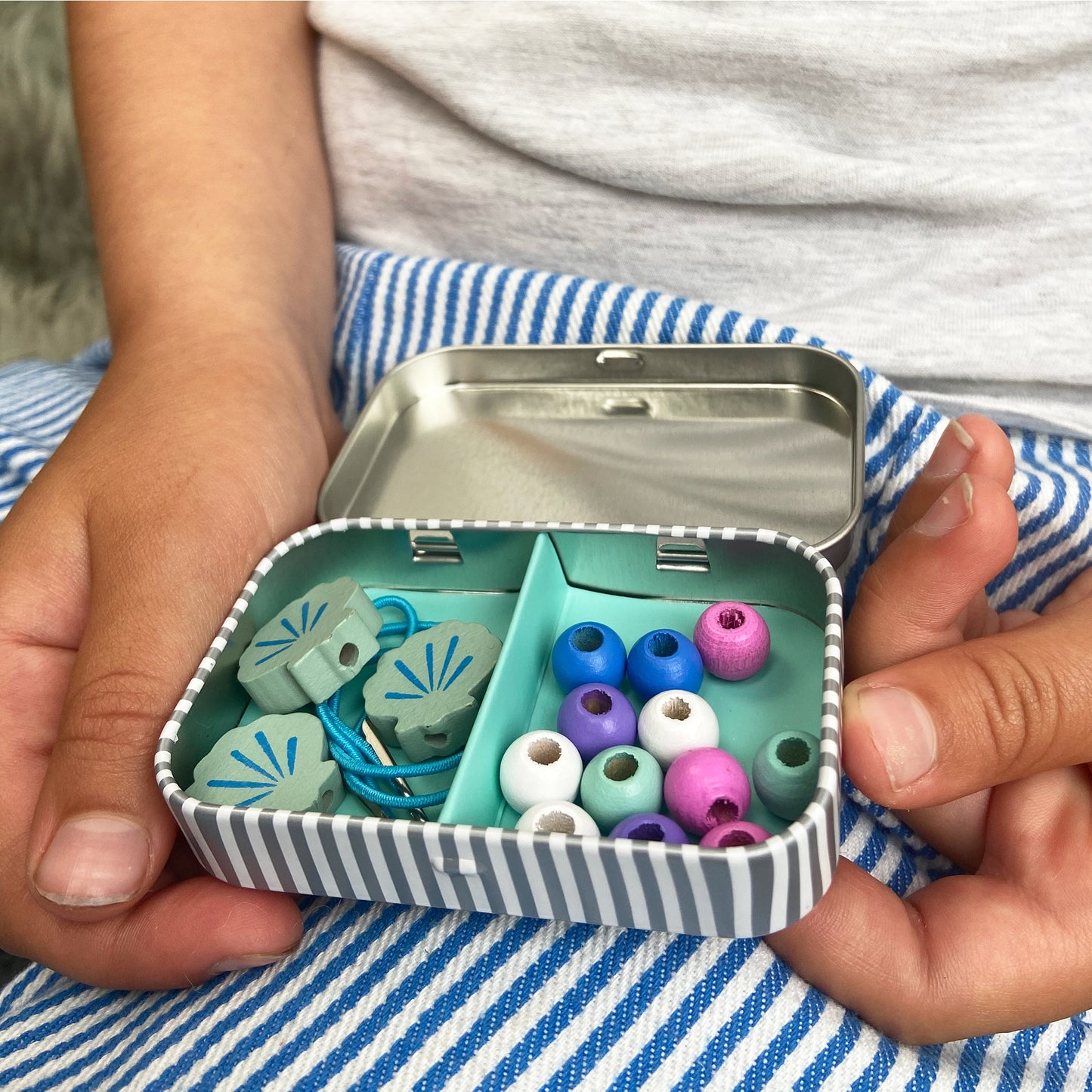 A beautiful gift tin containing elastic & beads to create a unicorn or mermaid bracelet. The elastic comes with hard ends to aid the beading process for young children. 100% plastic free.