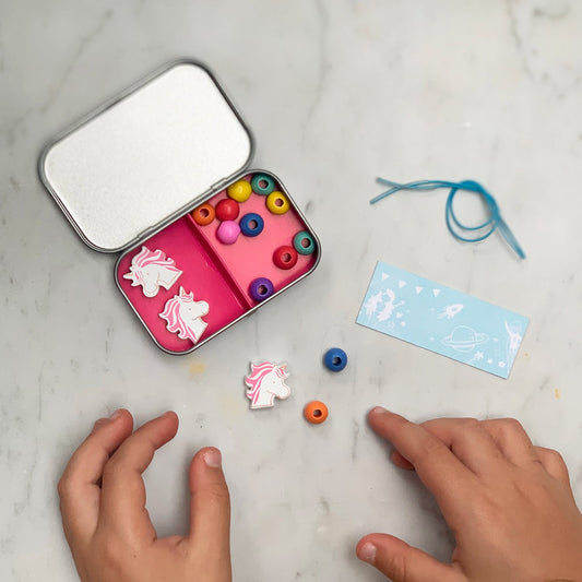 A beautiful gift tin containing elastic & beads to create a unicorn or mermaid bracelet. The elastic comes with hard ends to aid the beading process for young children. 100% plastic free.