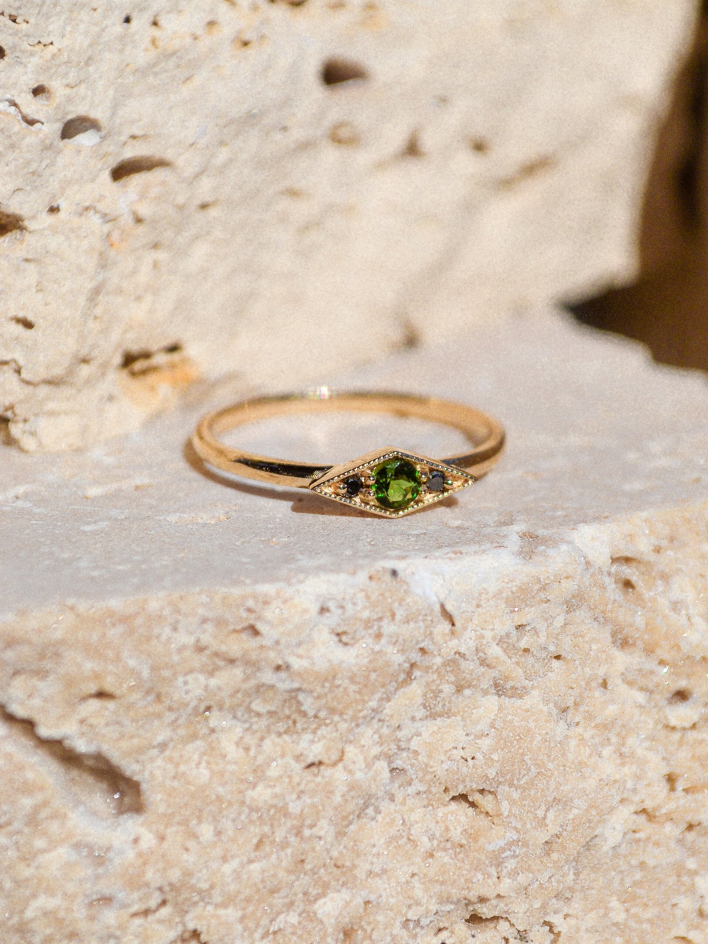 Deep blue green tourmaline encompassed in a diamond shape of solid 14k yellow gold and 2 black diamonds. A one of a kind ring inspired by an island in Scotland. Each Miarante piece is carefully handcrafted in Chicago by a skilled production team.