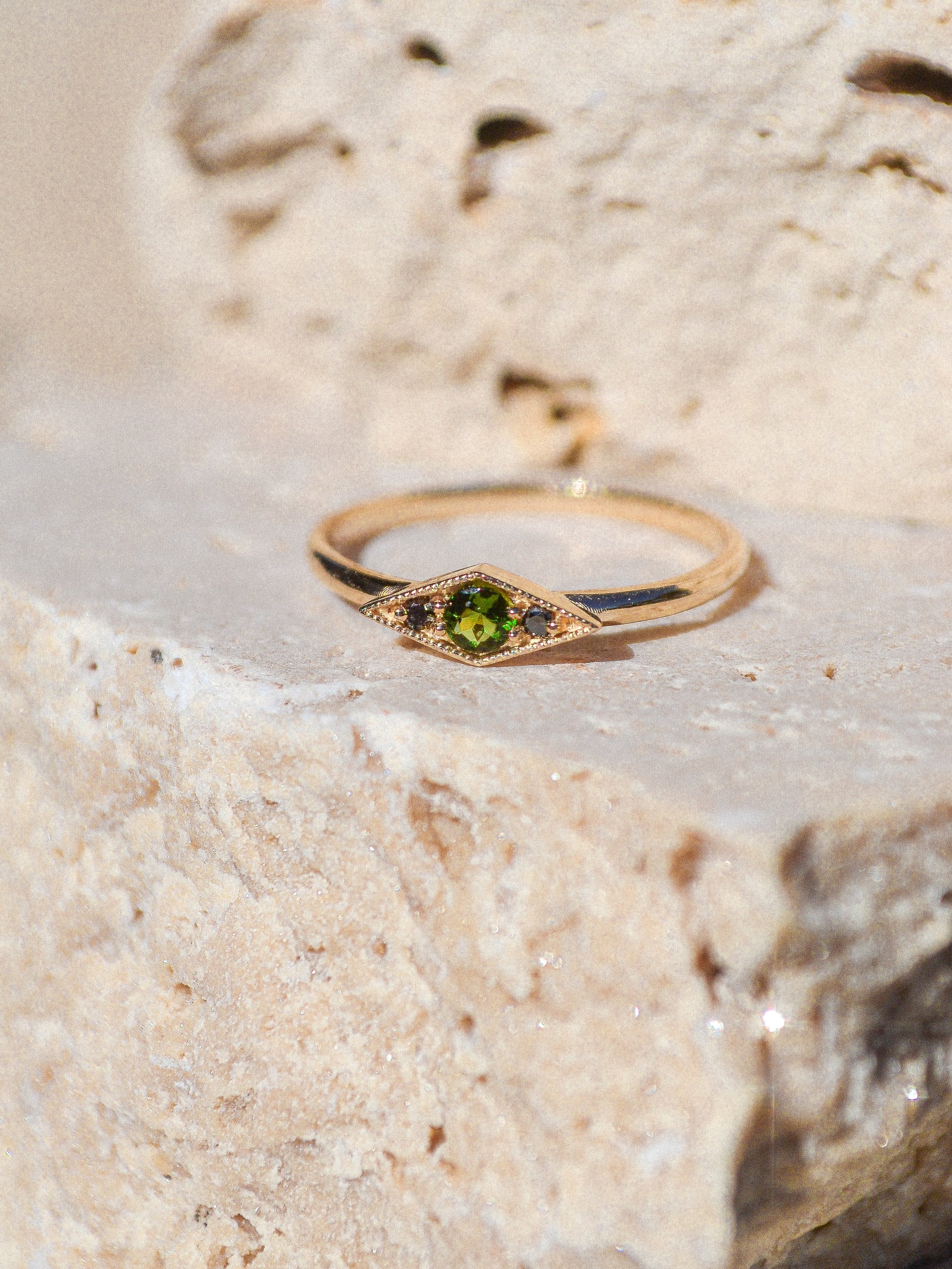 Deep blue green tourmaline encompassed in a diamond shape of solid 14k yellow gold and 2 black diamonds. A one of a kind ring inspired by an island in Scotland. Each Miarante piece is carefully handcrafted in Chicago by a skilled production team.