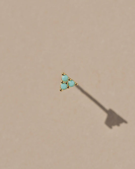 A tiny delicate triangular stud earring with triple prong set turquoise stones. Handmade in the Santa Cruz Mountains.