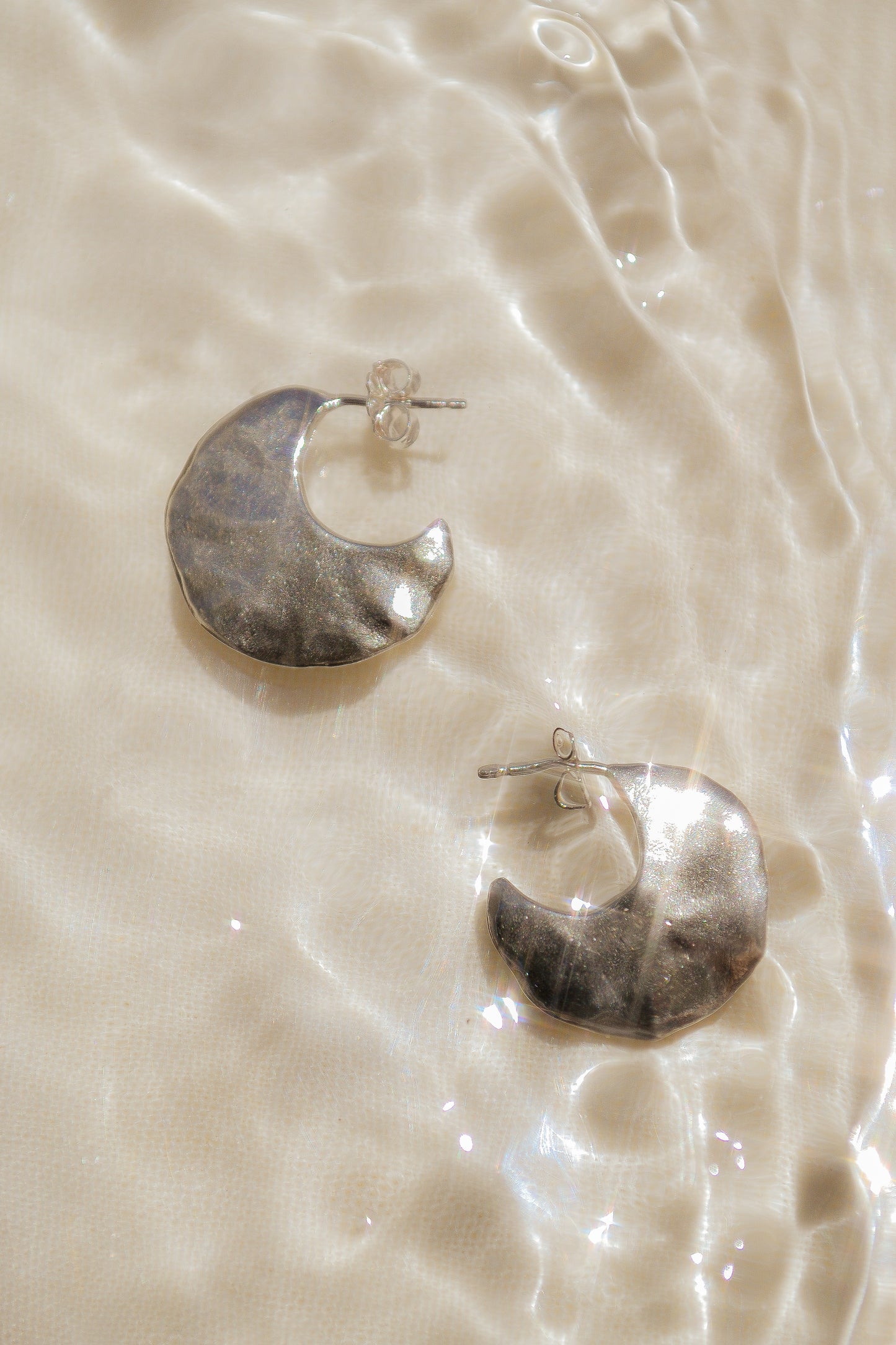 Bora Hoops by Amanda Hunt. A smooth yet slightly textured hoop. Light as a feather. Available in hand cast sterling silver with sterling silver posts or hand cast yellow bronze.