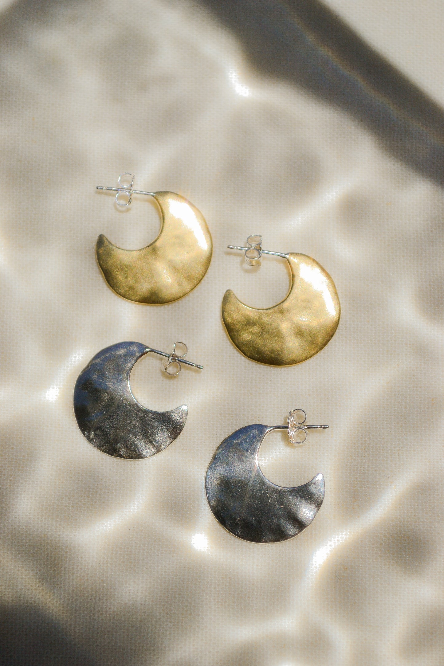 Bora Hoops by Amanda Hunt. A smooth yet slightly textured hoop. Light as a feather. Available in hand cast sterling silver with sterling silver posts or hand cast yellow bronze.