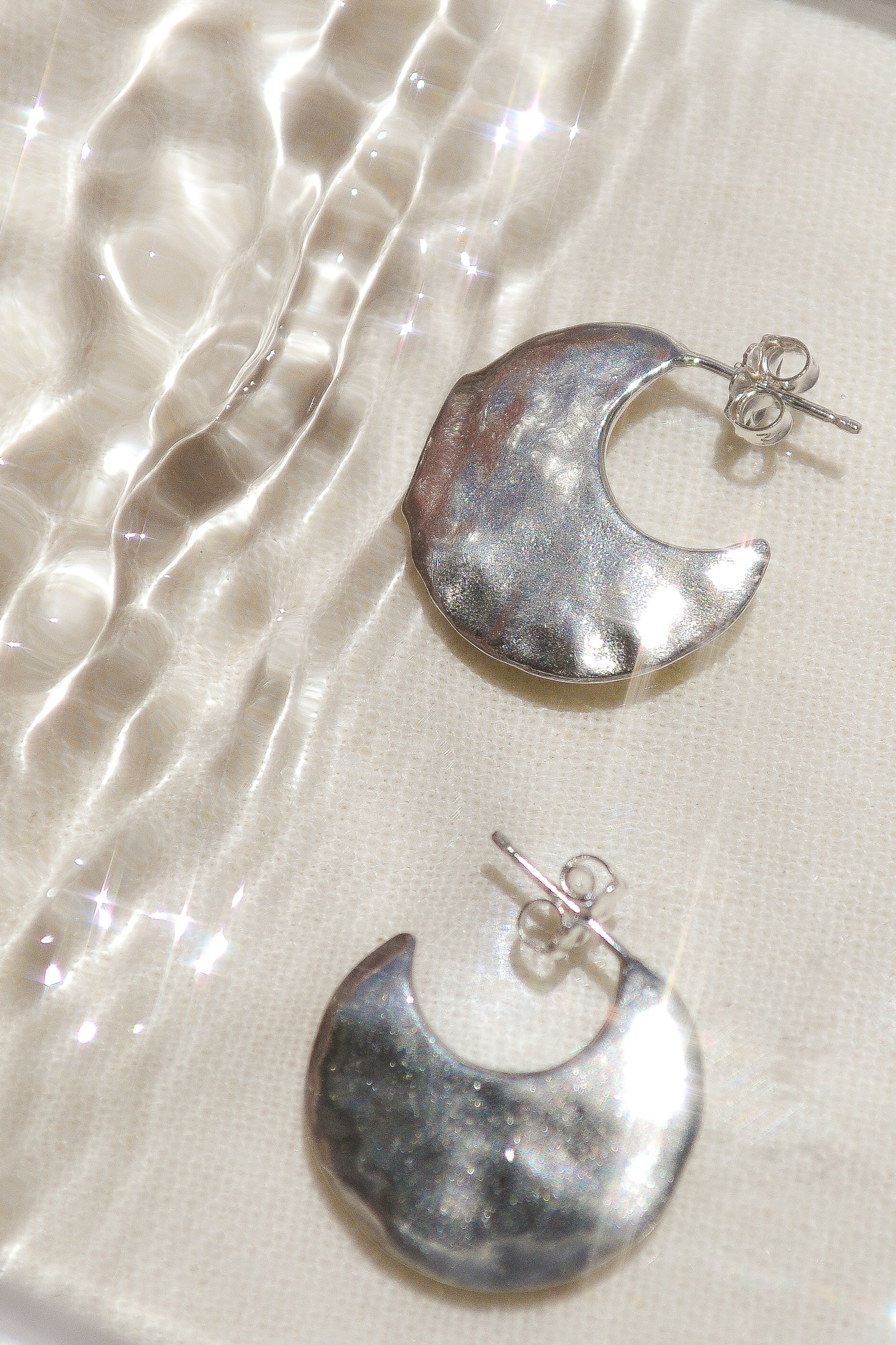 Bora Hoops by Amanda Hunt. A smooth yet slightly textured hoop. Light as a feather. Available in hand cast sterling silver with sterling silver posts or hand cast yellow bronze.