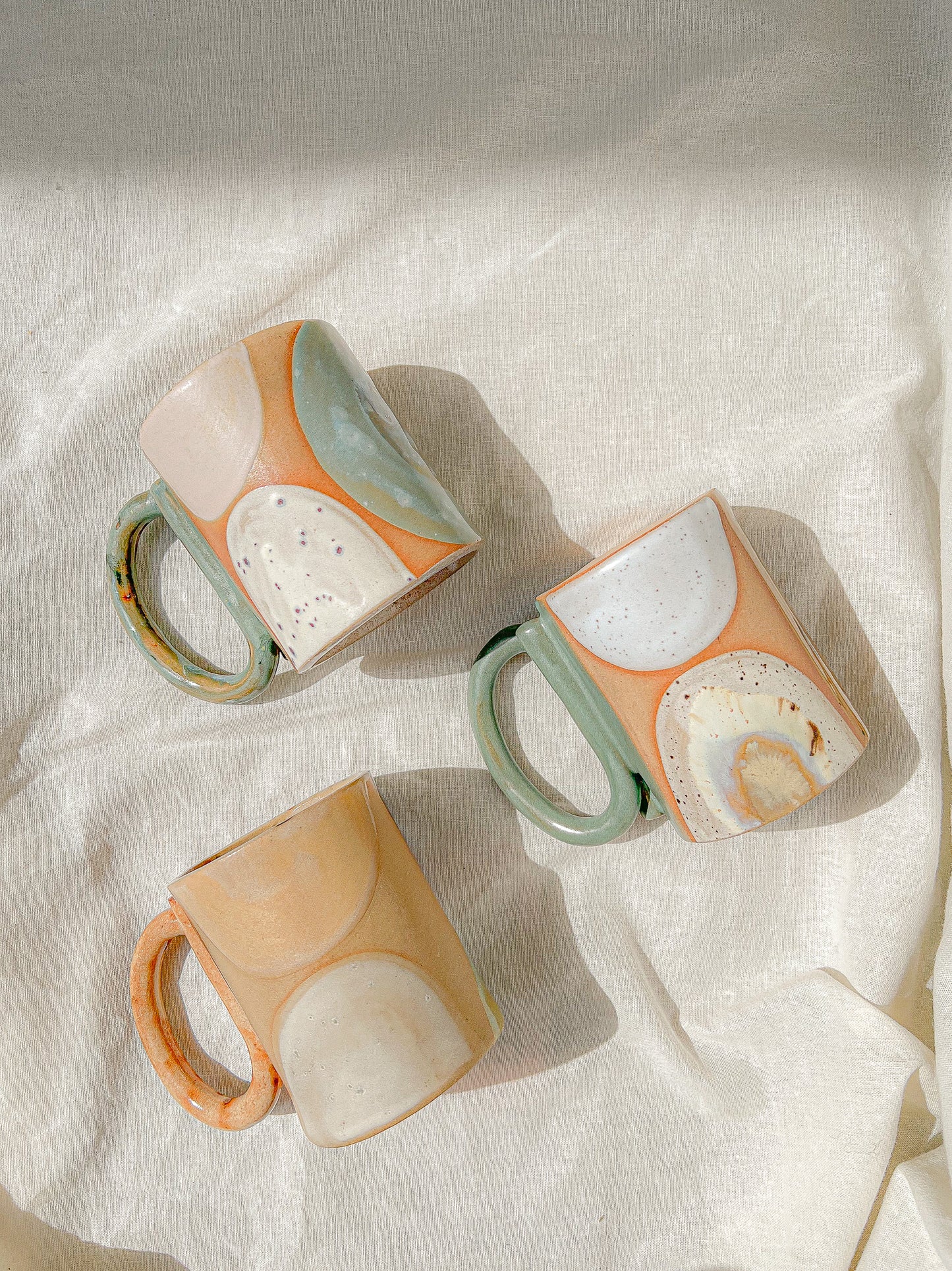 Handmade ceramic mug featuring unique glaze colors and a looped handle.