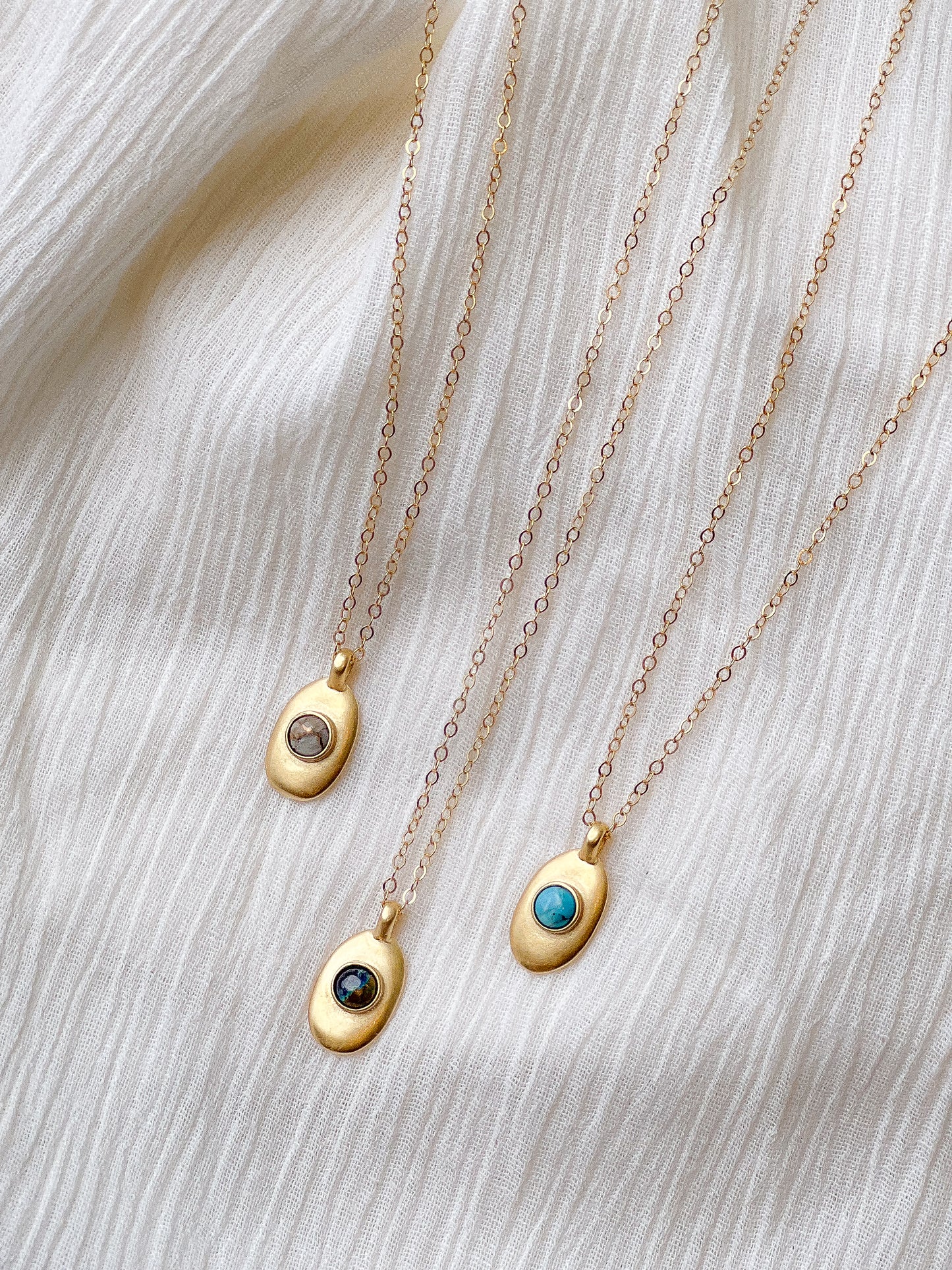 Sweet little handmade charm necklace featuring an ethically-mined turquoise, azurite, or copper calcite stone stone. Bronze with gold plating and a gold filled chain.