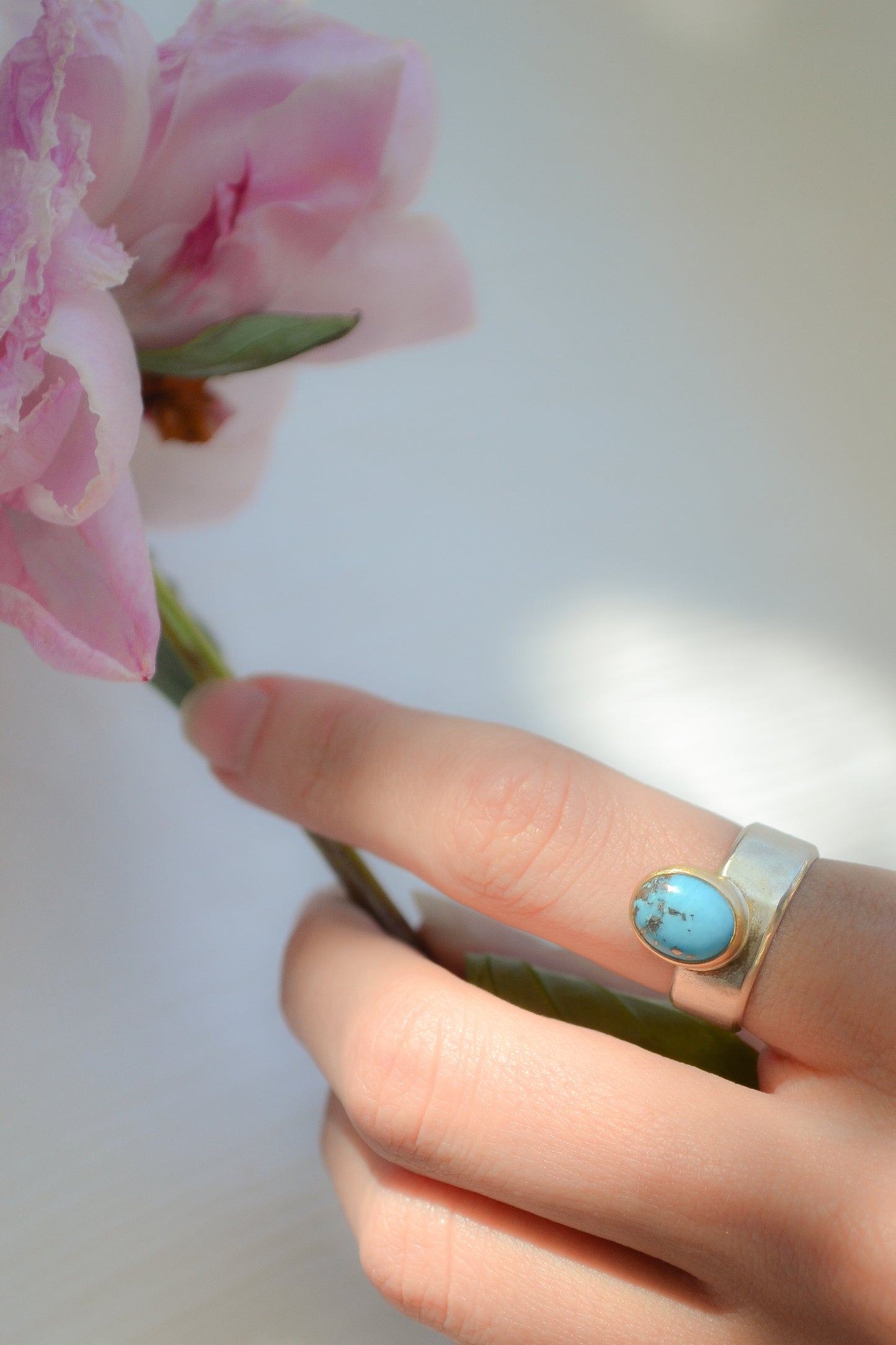 Made by hand in Northern New Mexico using recycled metals and responsibly sourced stones. This ring features a large cabochon Persian Turquoise stone set in a 14k yellow Gold bezel on a wide Sterling Silver band with matte finish. Mesa Ring by Halcyon Jewelry.