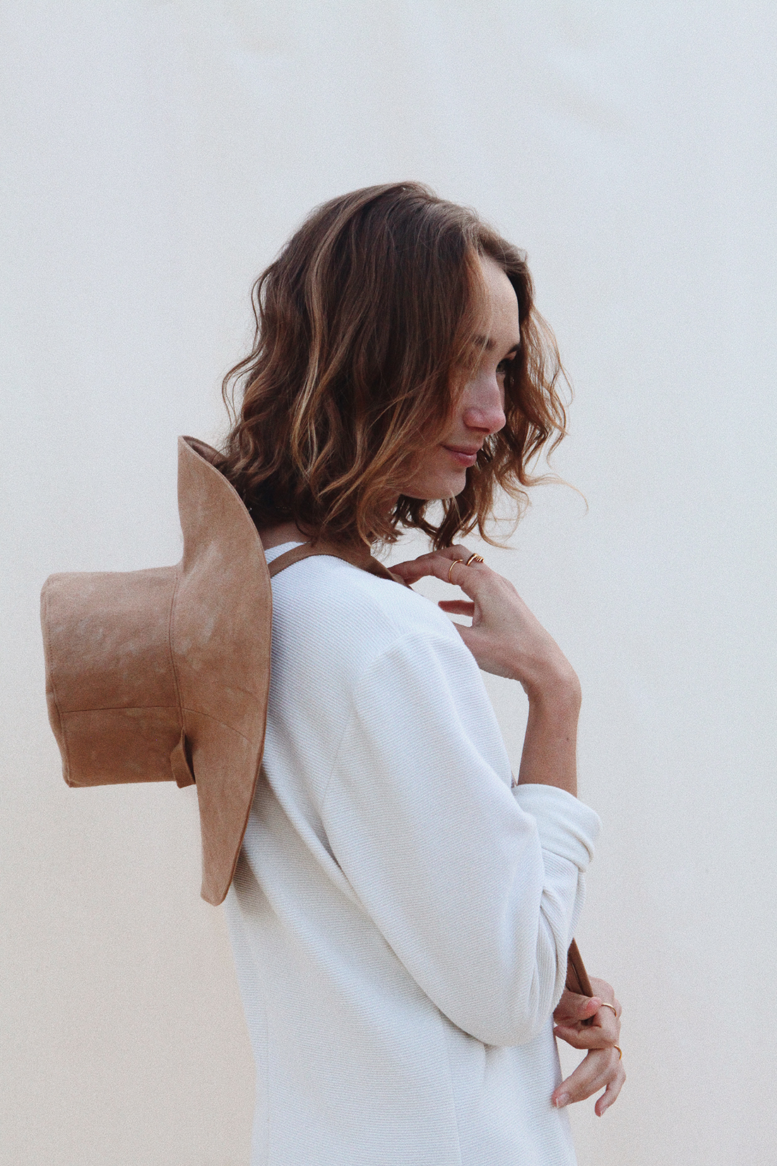 Thread Spun shop manager Jo wearing the Pair Up Sun Hat in Desert Sand, one of the sustainable San Diego based brand carried in the shop