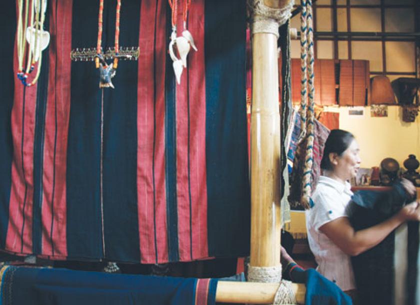 Owner of Thread Spun artisan partner, Yoyamay, arranges hand woven textiles.