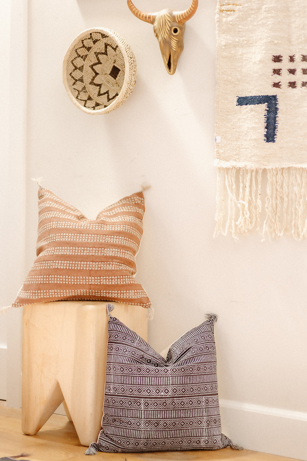 Handmade pillows from India with a handwoven basket from East Africa and an ethically-made wall hanging from Mexico