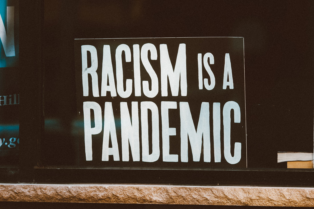Racism is a Pandemic sign in a business window