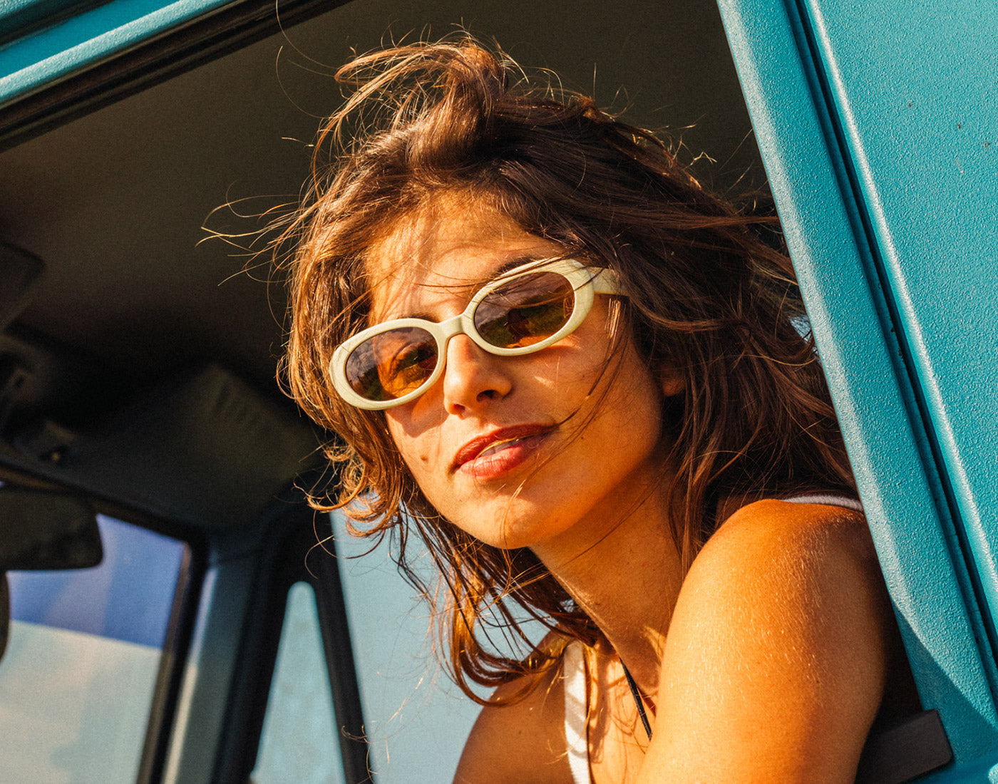 A woman smiles wearing Sunski polarized sunglasses that are made sustainably