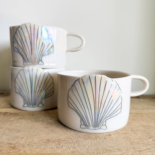 Seashell mugs are hand-thrown from fine porcelain, and feature hand drawn inlay and mother of pearl luster for a delicate and iridescent shine.