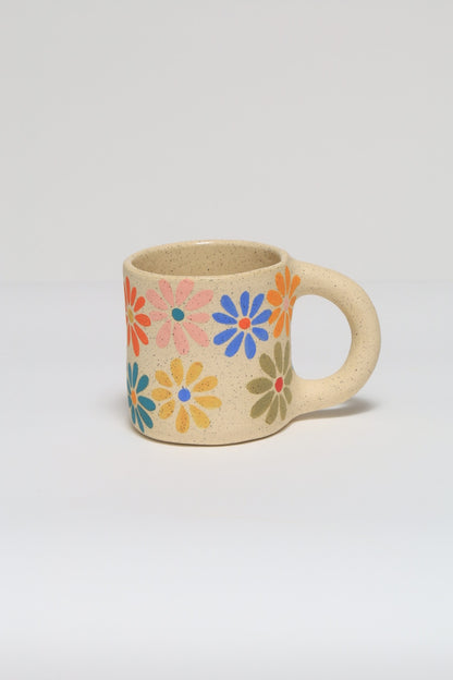 Handmade ceramic mug featuring a hand painted flower design in colorful underglaze. melville ceramics