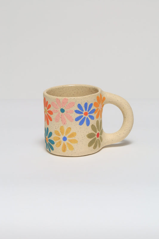 Handmade ceramic mug featuring a hand painted flower design in colorful underglaze. melville ceramics