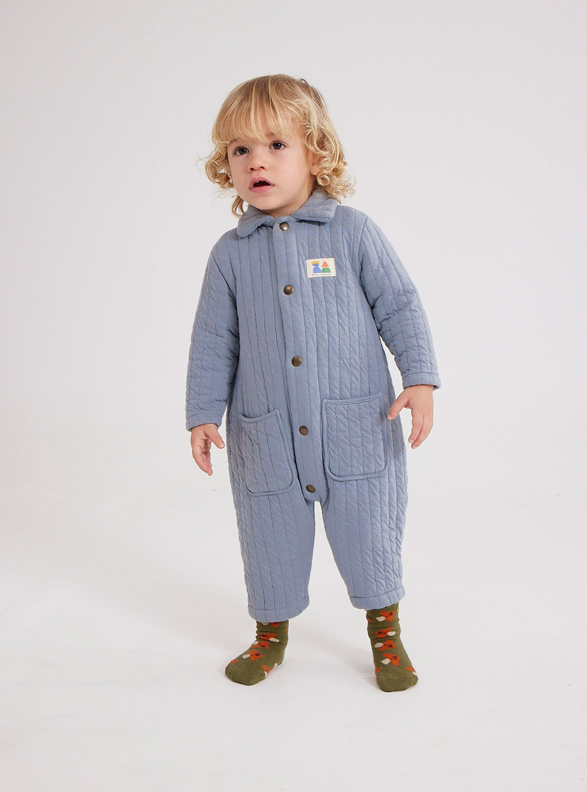 Bobo Choses Baby Quilted Overalls - 78% cotton 22% polyester blue overall. Designed with spread collar, front snap fastening, crotch snap fastening, patch and patch pocket. It has a relaxed fit. Made in Portugal.